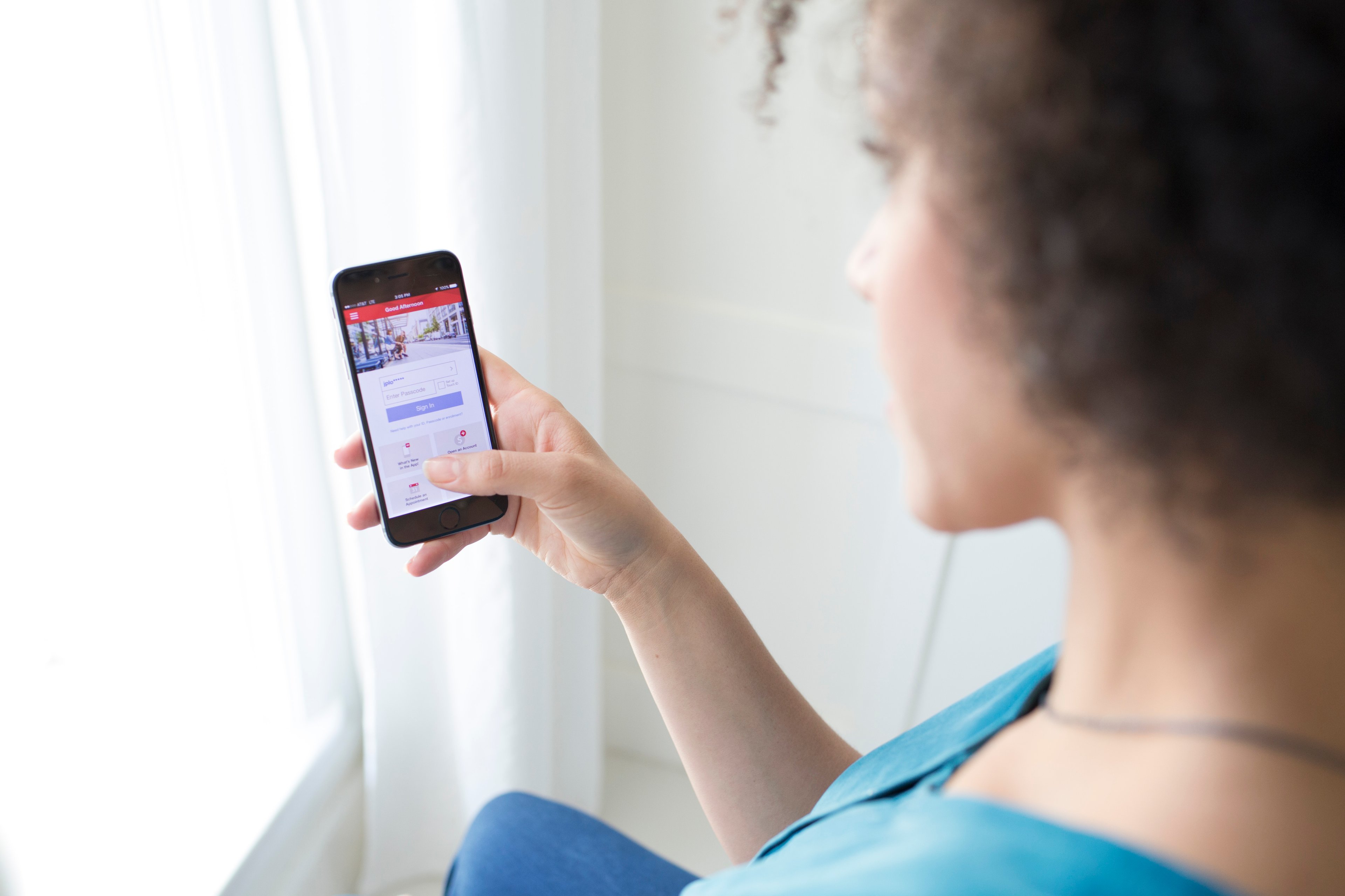 A woman using Bank of America's mobile app on a smartphone.