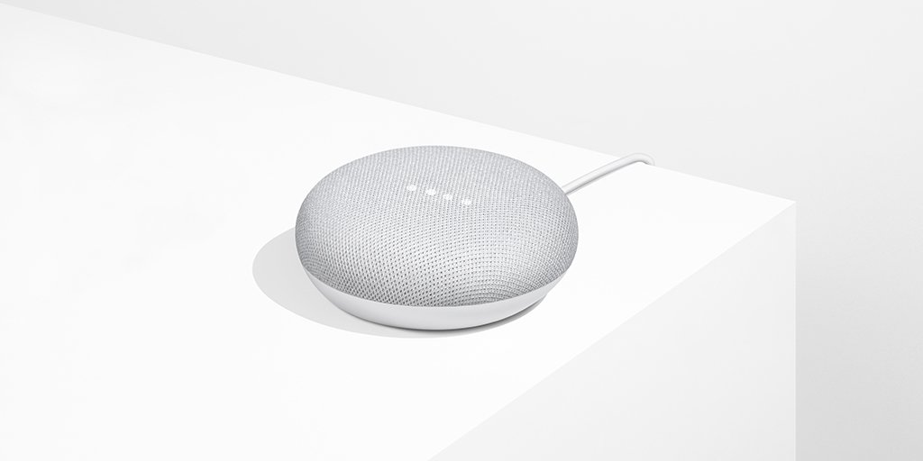 Google Home Mini smart speaker on a white surface