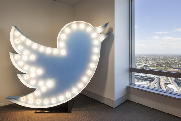 An illuminated Twitter bird logo next to a window