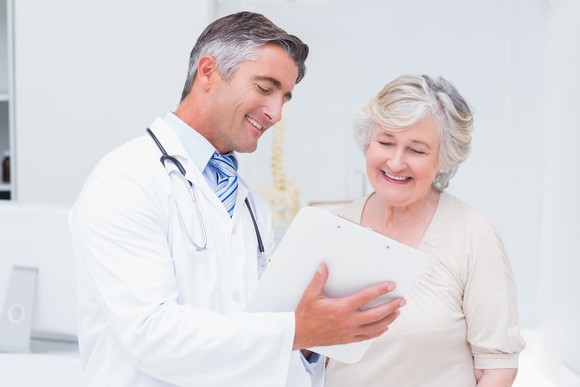 Doctor and patient looking at a piece of paper and smiling