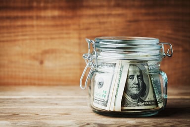 Dollar bills rolled up in a jar