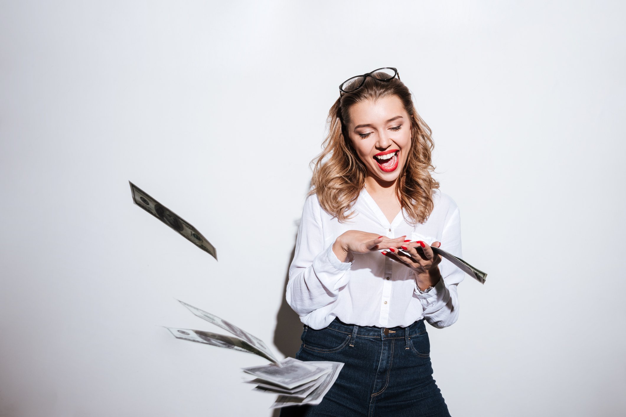A young woman excitedly throwing cash.