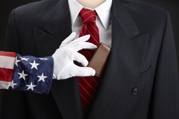 Uncle Sam grabbing a wallet from a businessman.