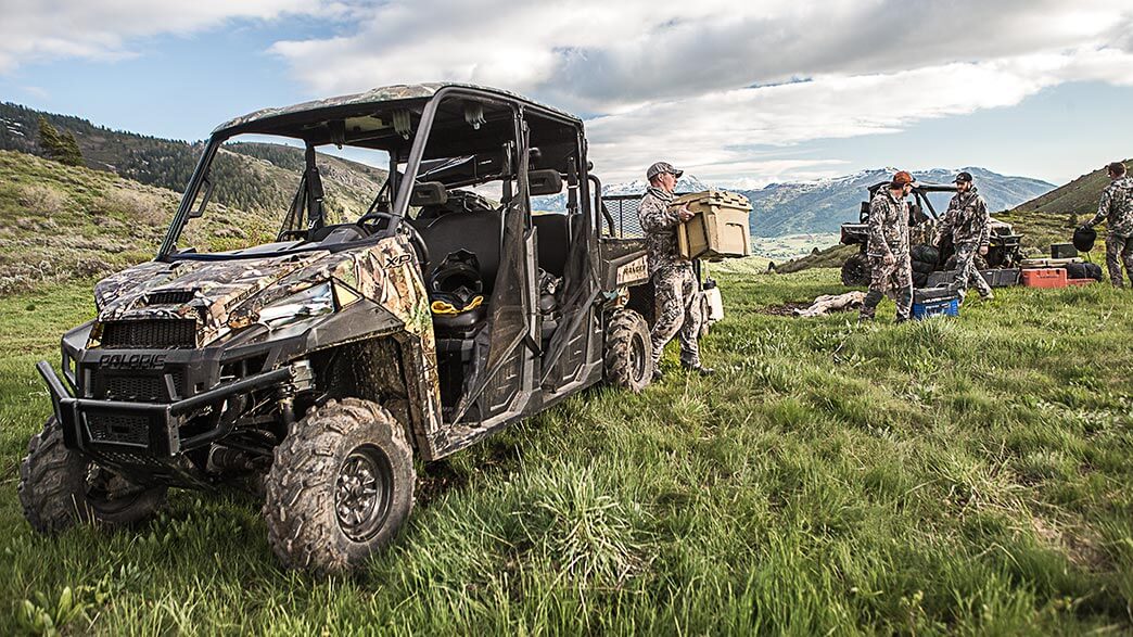 Hunters unloading a Polaris Ranger XP 1000 in a grass field