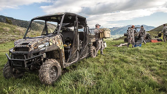 Hunters unloading a Polaris Ranger XP 1000 in a grass field