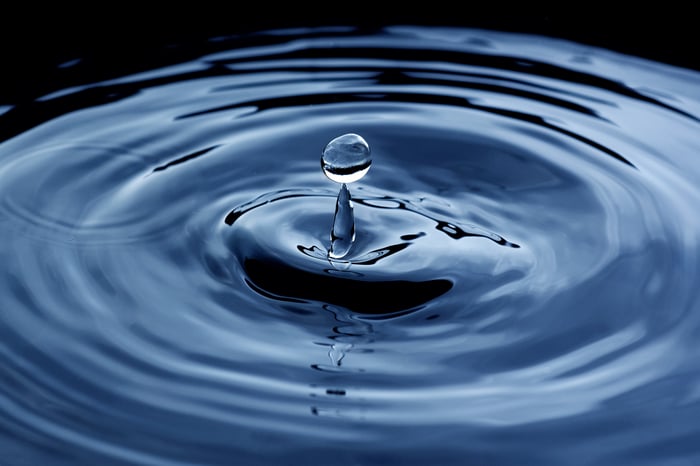 A water drop splashes down and sends out ripples.