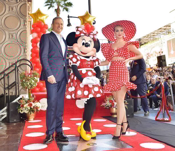 Minnie Mouse poses with CEO Bob Iger and a woman for Minnie's star on the Hollywood Walk of Fame