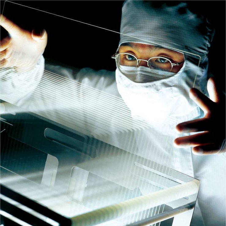 A Corning employee holds an LCD screen.