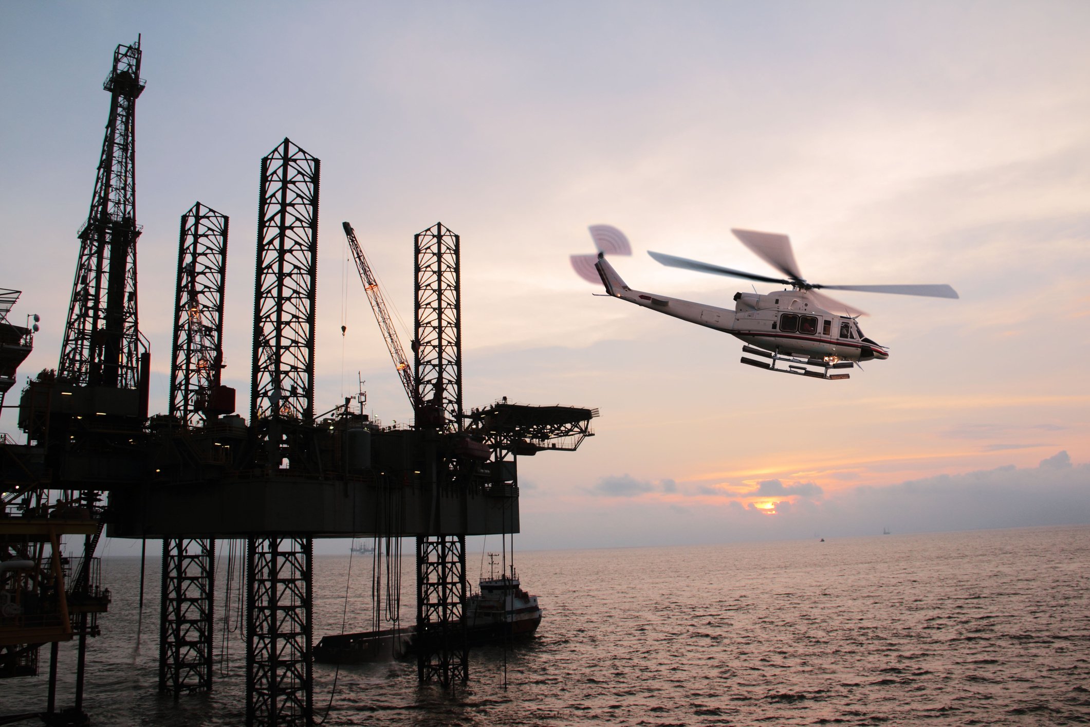 A helicopter taking off from an offshore oil rig.
