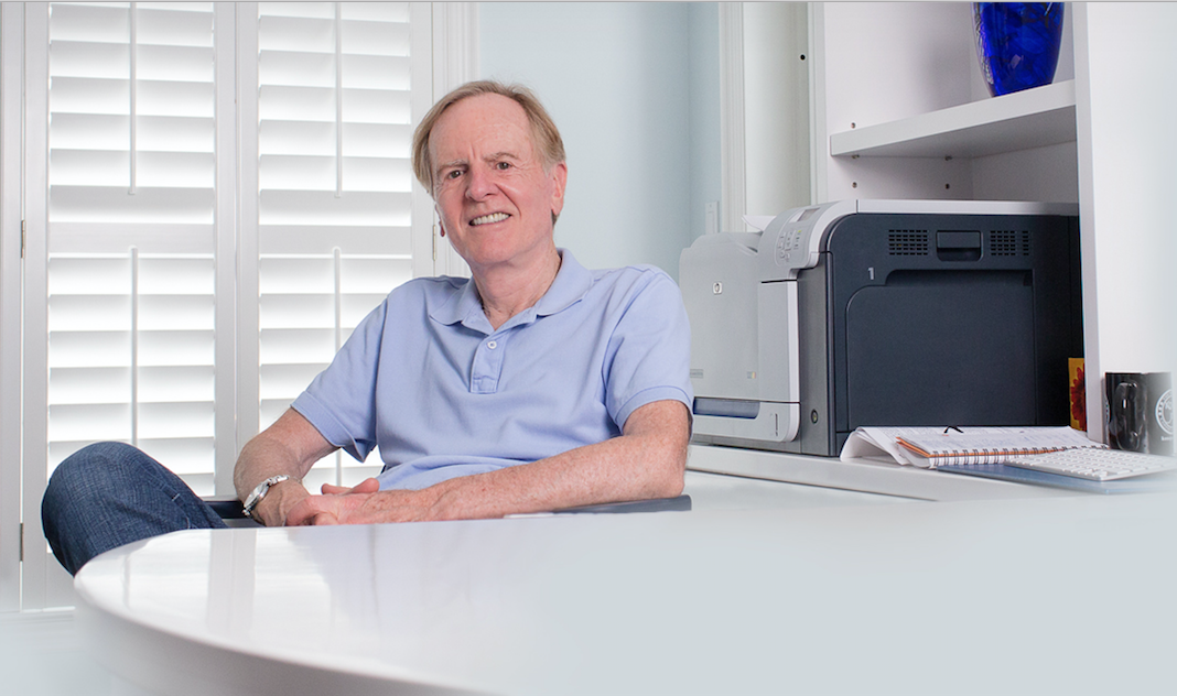 John Sculley sitting at a desk