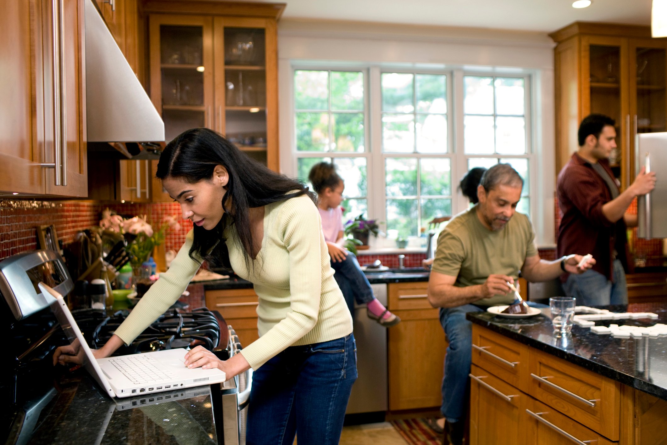 Multiple generations are seen in a kitchen.