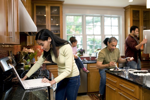Multiple generations are seen in a kitchen.
