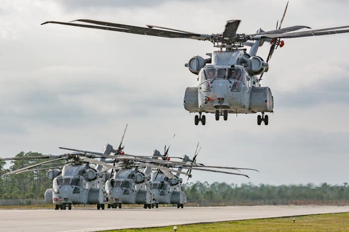 Several CH-53K helicopters, one coming in for a landing