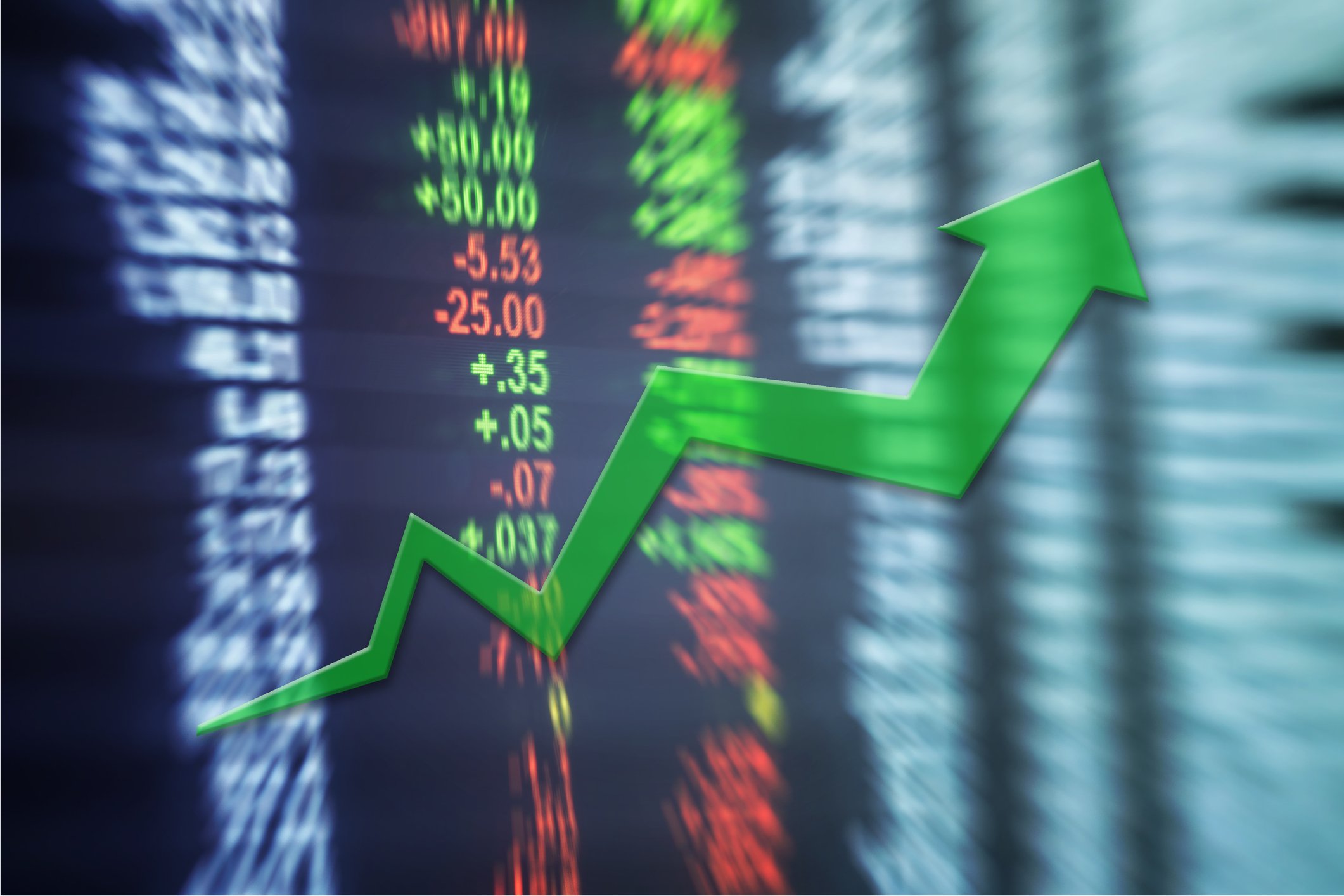 Blurred chart of asset prices with green upward arrow over them.