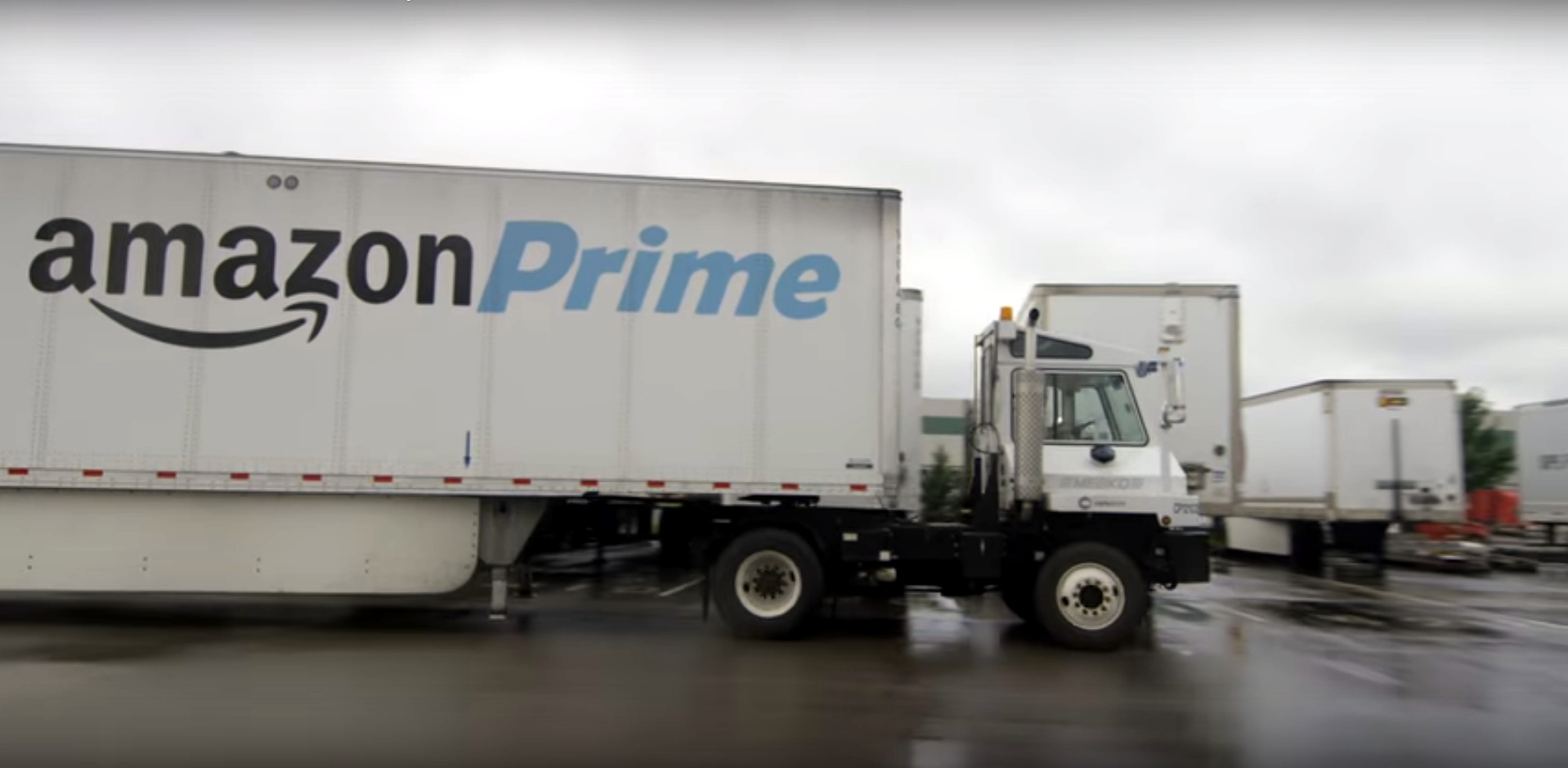 White semi truck with a black-and-blue Amazon Prime logo on the trailer.