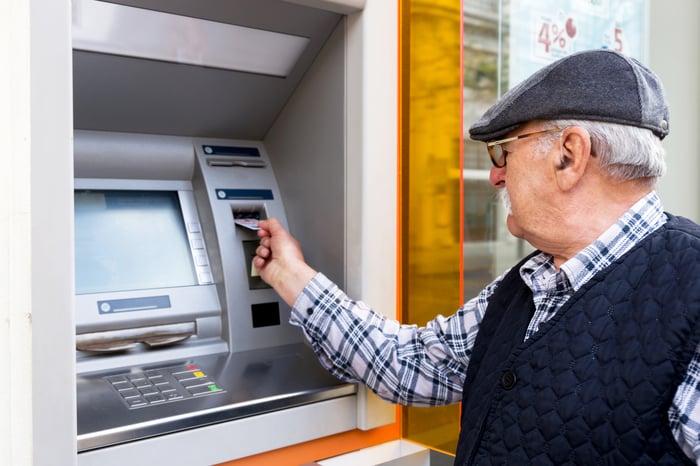 Older man using ATM.