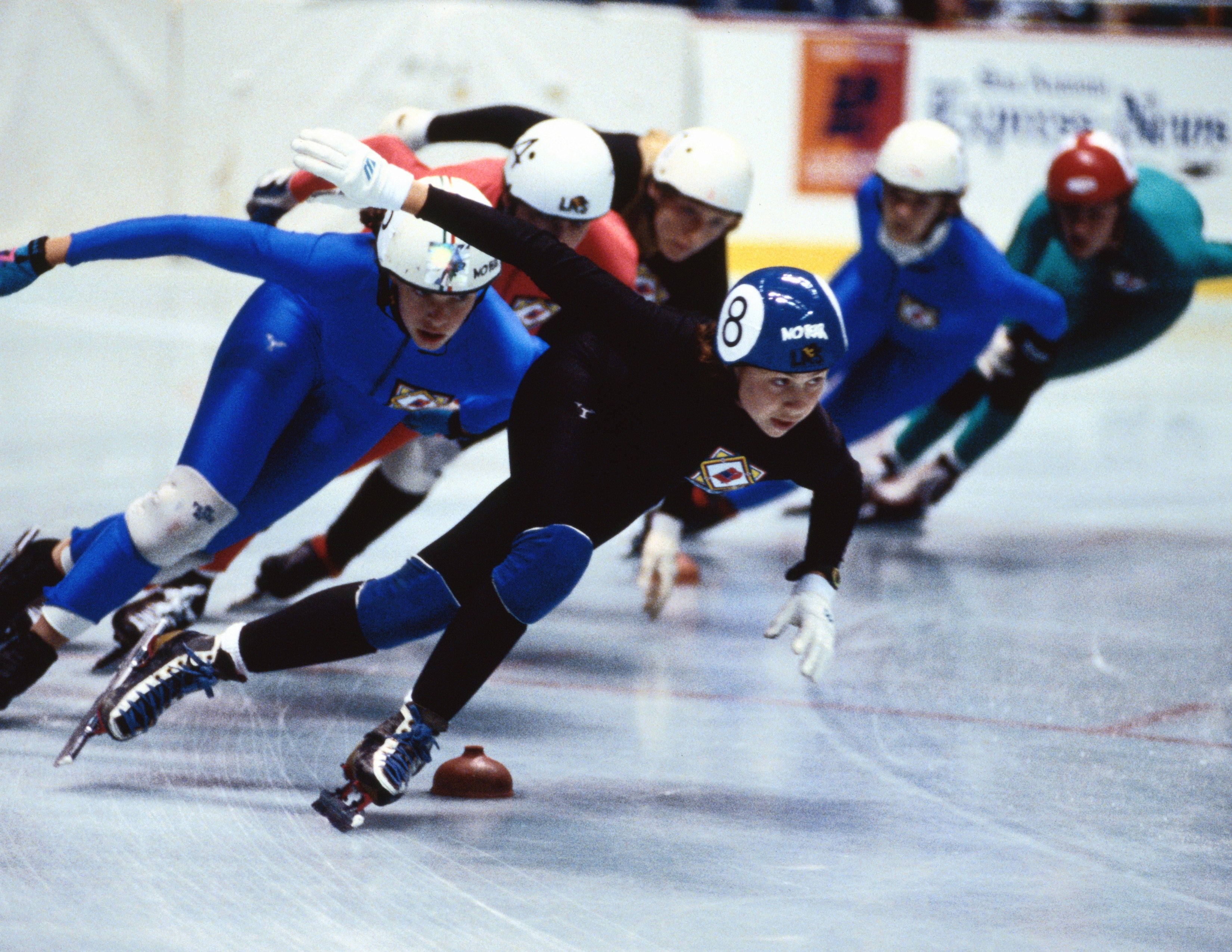 Speed skaters going around a turn.
