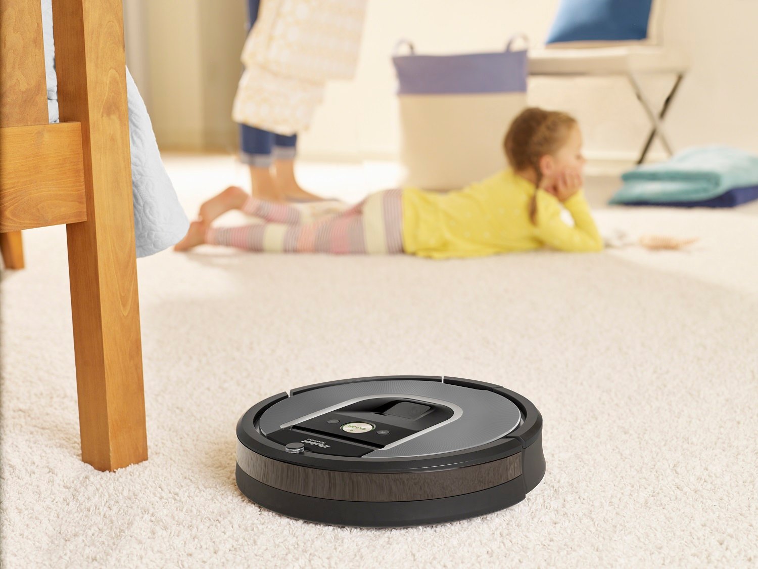 iRobot roomba cleaning the floors while a mother and child stand in the background