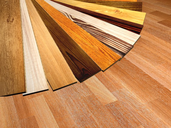 Various parquet wood flooring swatches in different colors fanned out on the floor.