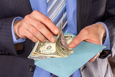 man in suit counting bills_GettyImages-471709246