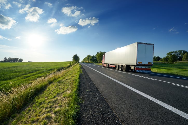 A tractor trailer driving down the highway.