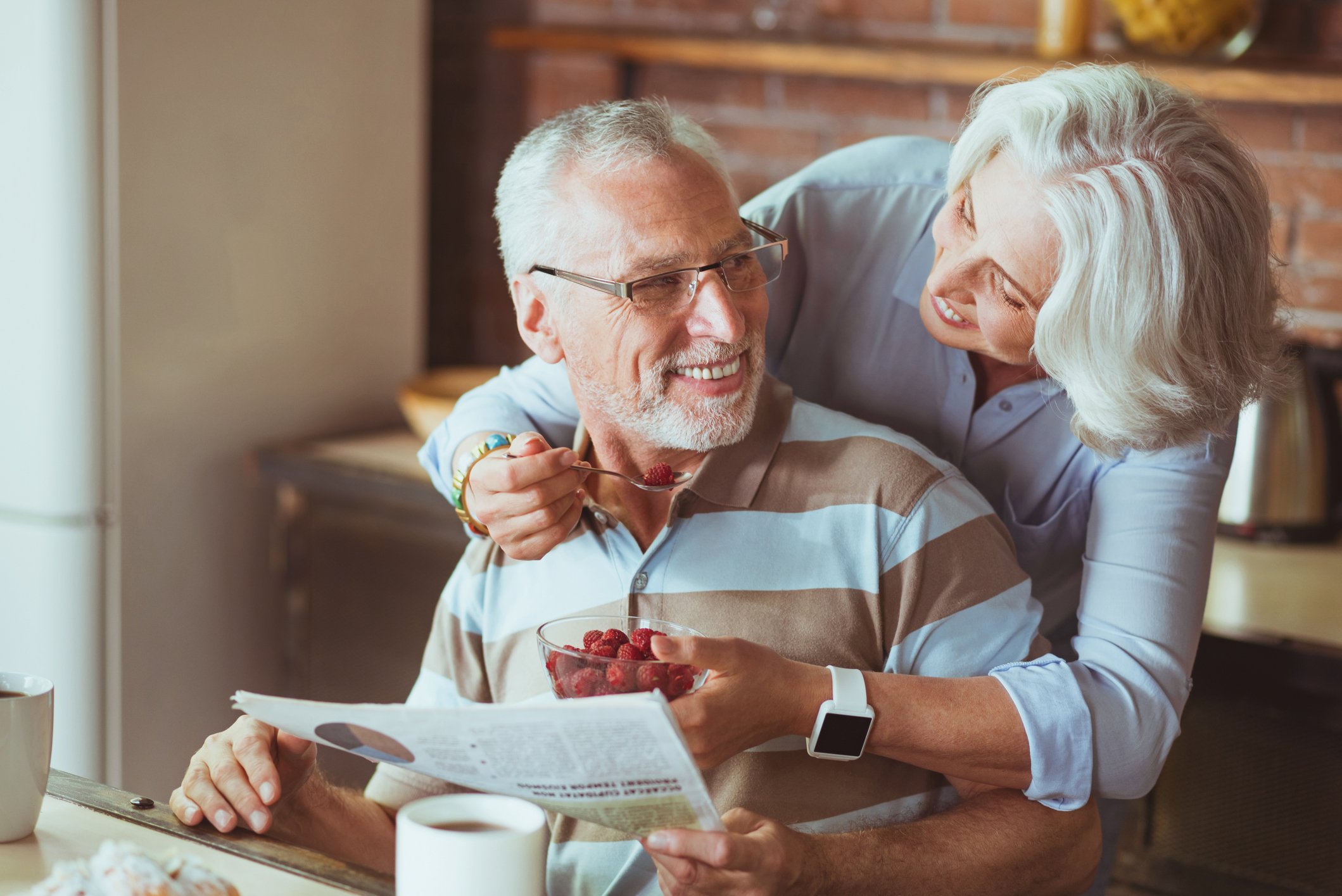 Loving aged couple enjoying their breakfast.