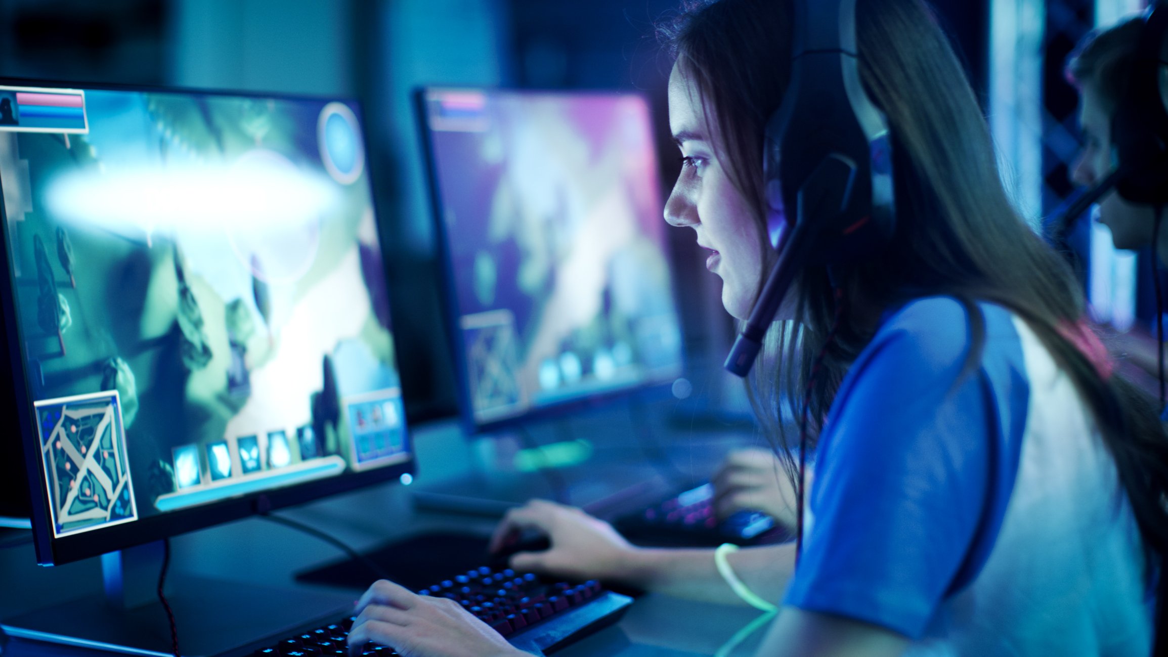 Woman sitting in front of a computer playing a video game.