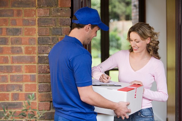 A woman signs for a delivery package.
