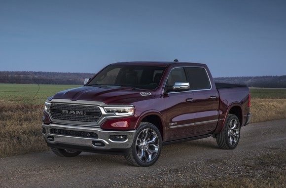 A dark red 2019 Ram 1500, a full-size pickup truck, parked next to a farm field. 