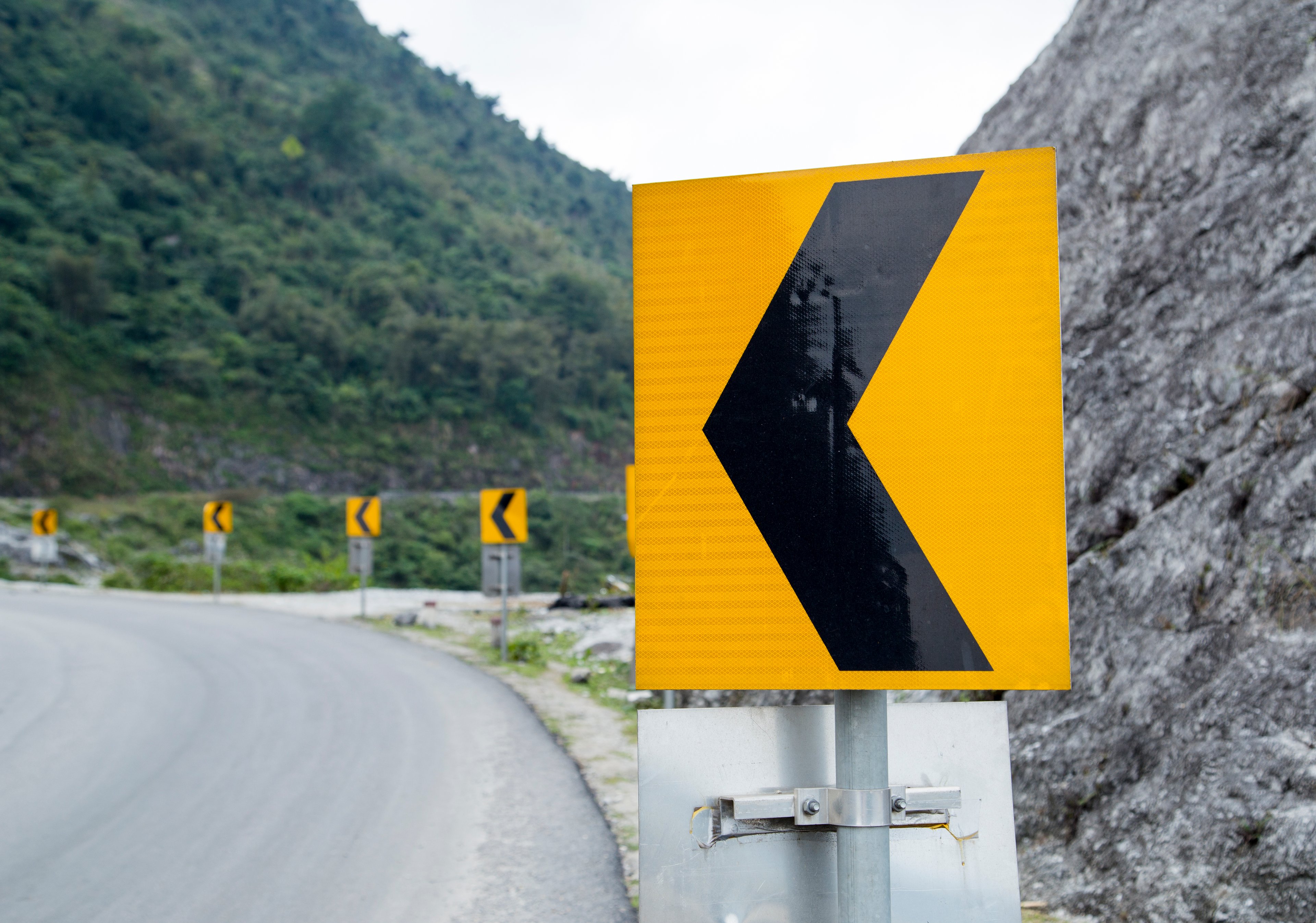 Curve warning sign on a mountain road.