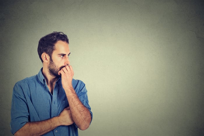 Worried man with hand covering his mouth