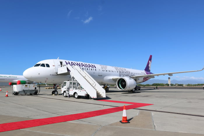 A Hawaiian Airlines A321neo parked on the tarmac, with airstairs attached