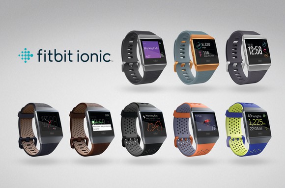 An advertisment featuring eight Fitbit Iconic smartwatches in different colors.