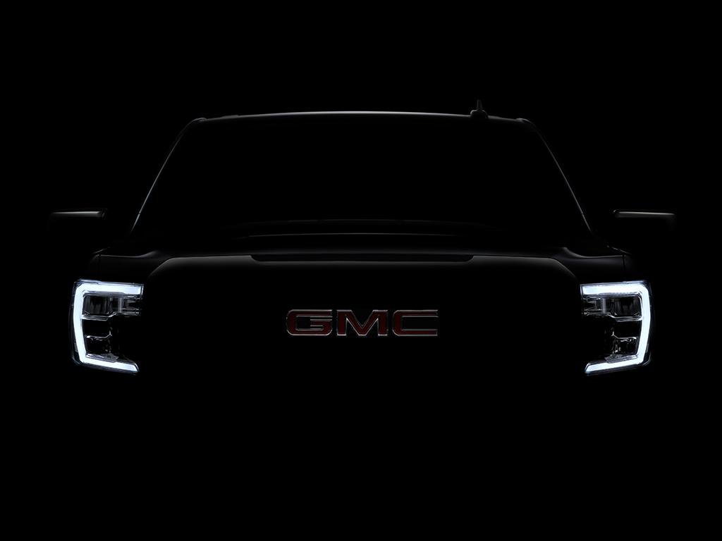 A darkened photo of the front end of the new GMC Sierra.