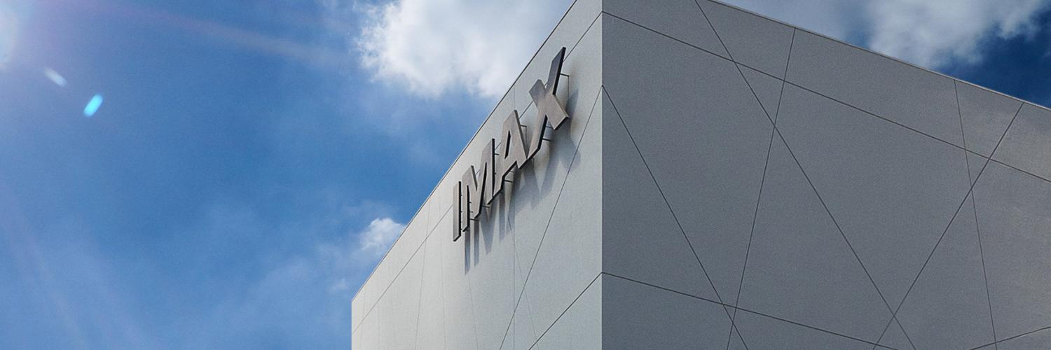 Blue sky with gray building labeled IMAX.