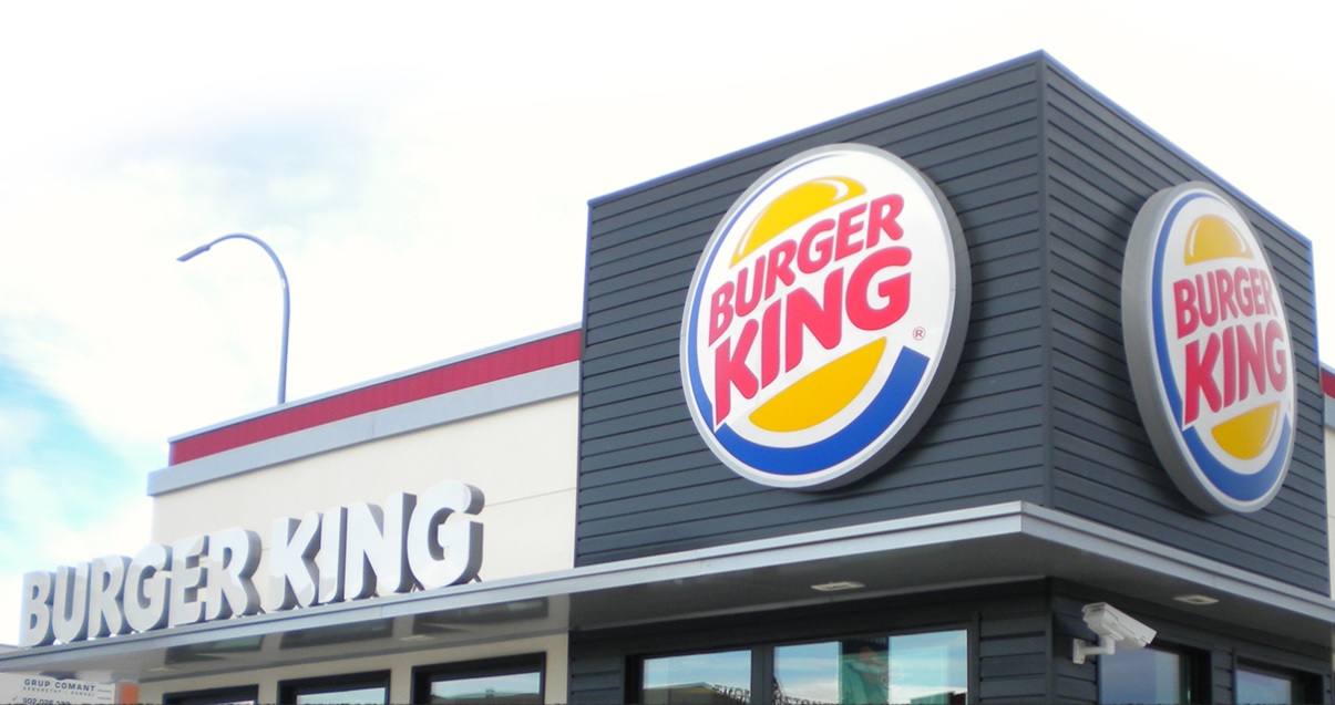 A Burger King Restaurant under white clouds during the day
