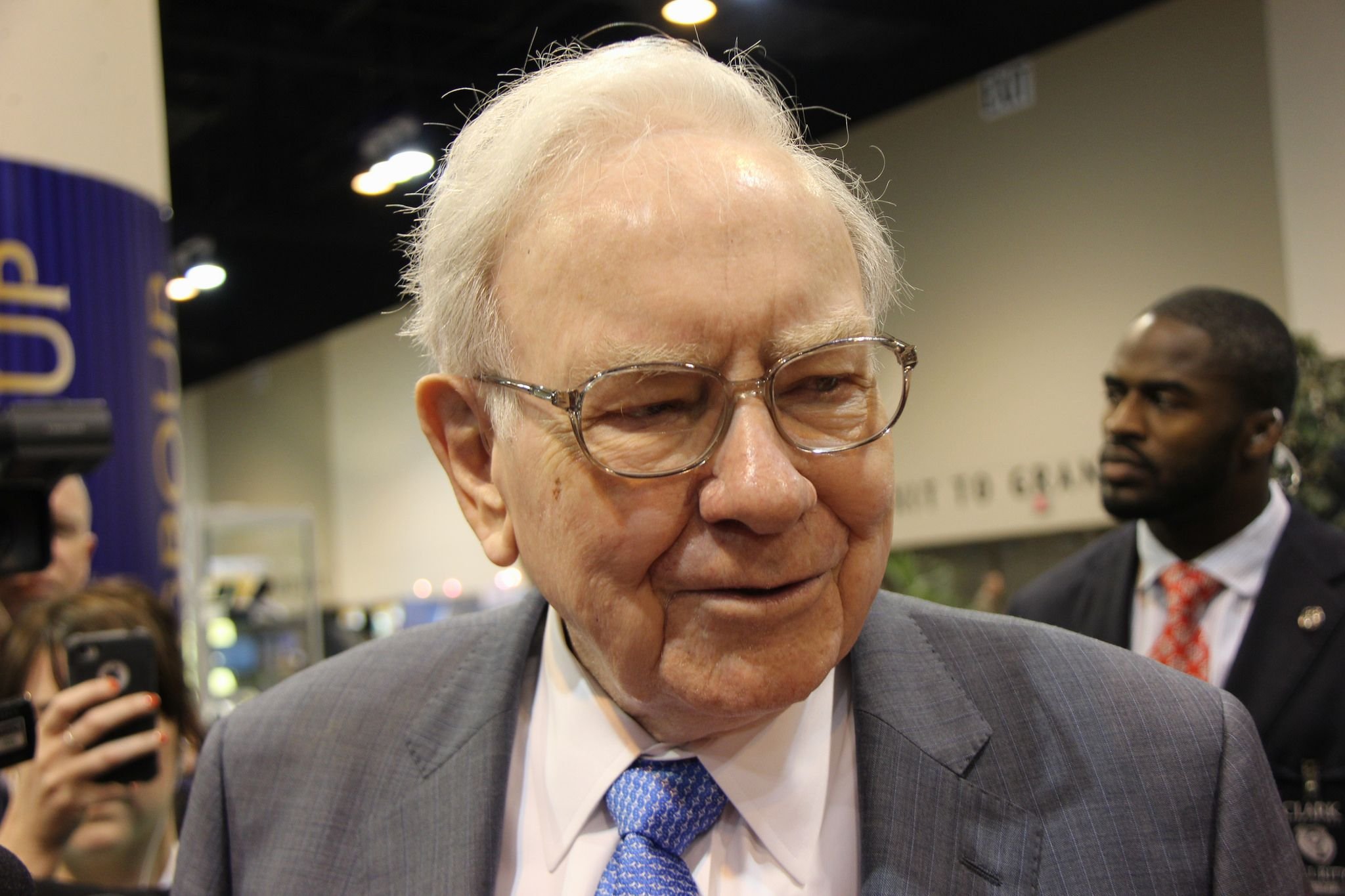 Warren Buffet walking among investors. 