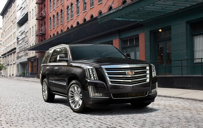 A black Cadillac Escalade, a large SUV, parked on a New York City street.