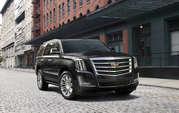 A black Cadillac Escalade, a large SUV, parked on a New York City street.