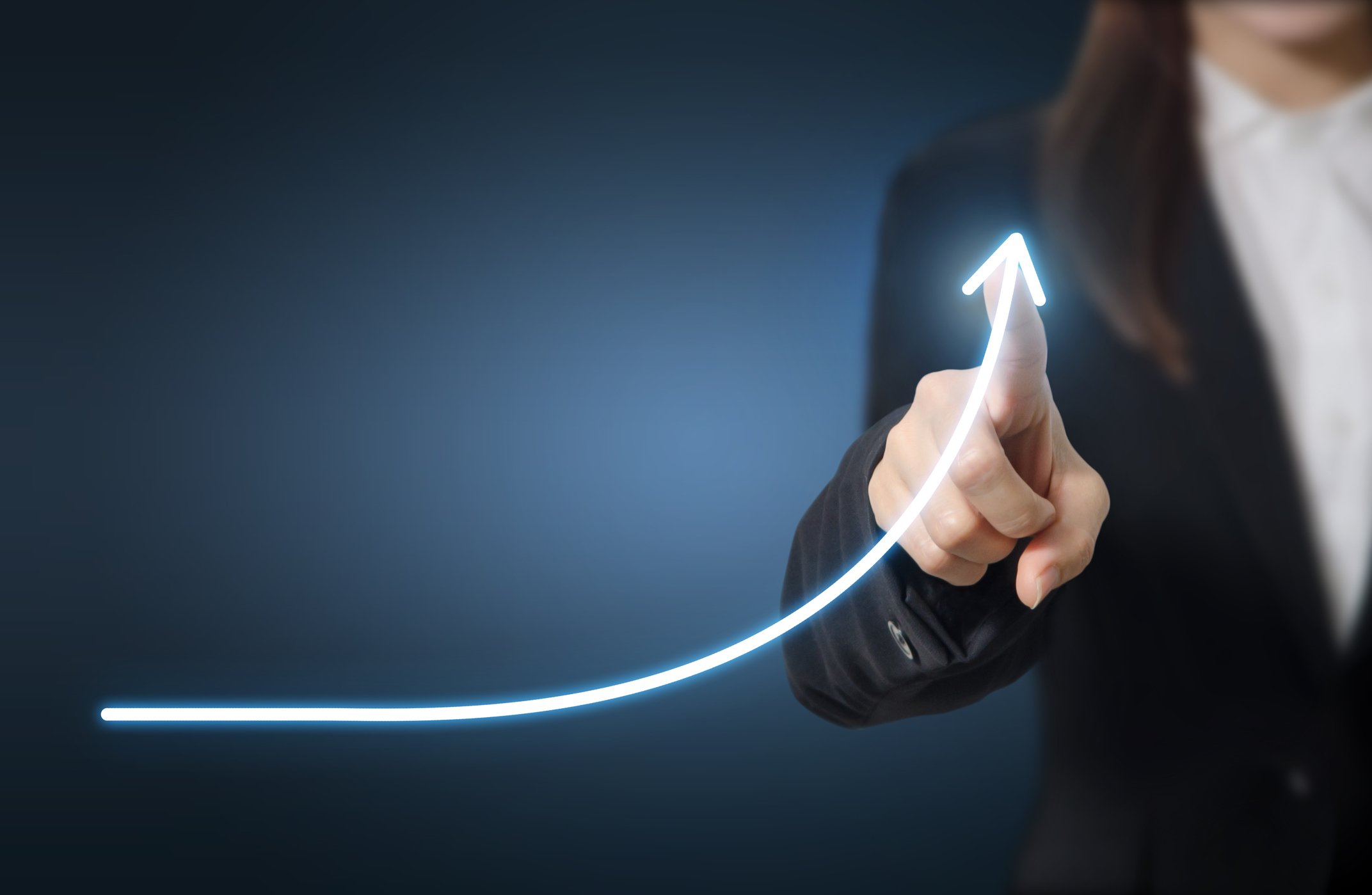 Woman in suit drawing a line indicating exponential growth.