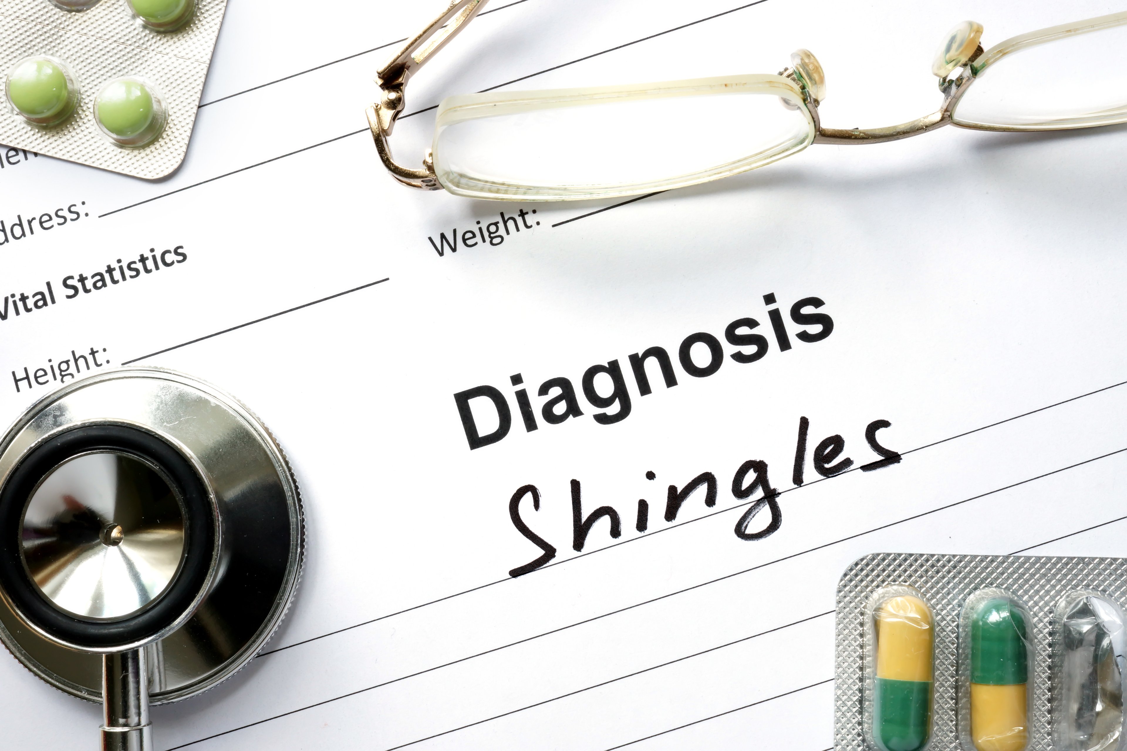 Paper reading Diagnosis: Shingles with medication, stethoscope, and glasses on it