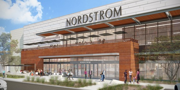 Nordstrom storefront with a terrace over the entrance with places for people to sit and people walking on the sidewalk outside in front of the store.