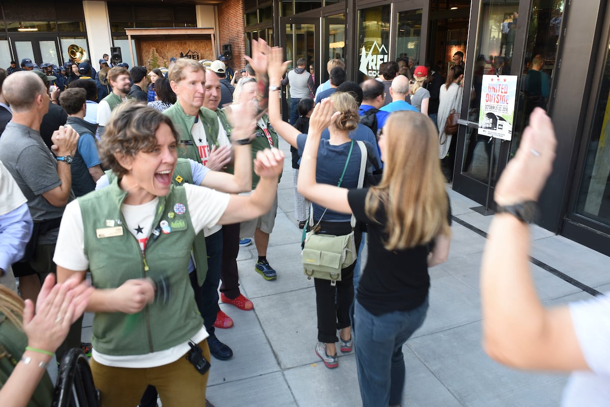 REI employees greeting customers are a store's grand opening