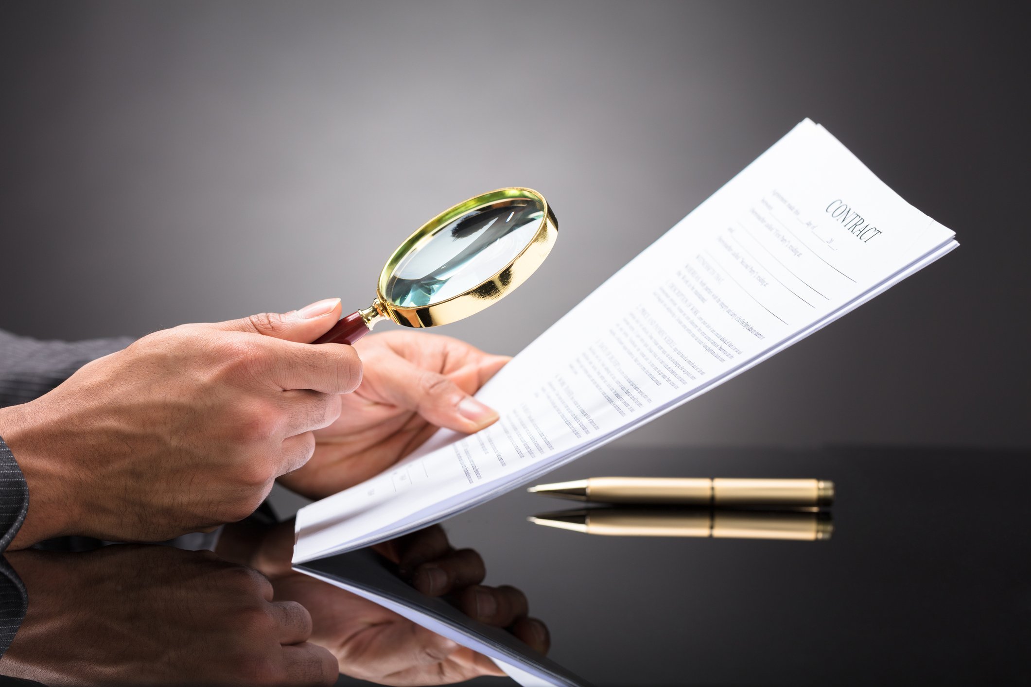 a man with a magnifying glass looking at a document