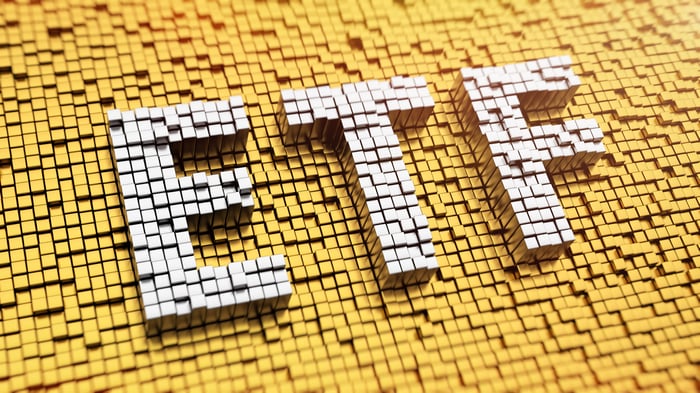 White mosaic tiles spelling ETF on a yellow mosaic tile background.