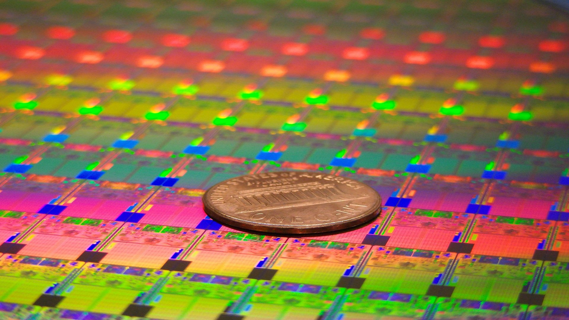 A wafer of Intel processors with a penny on top.