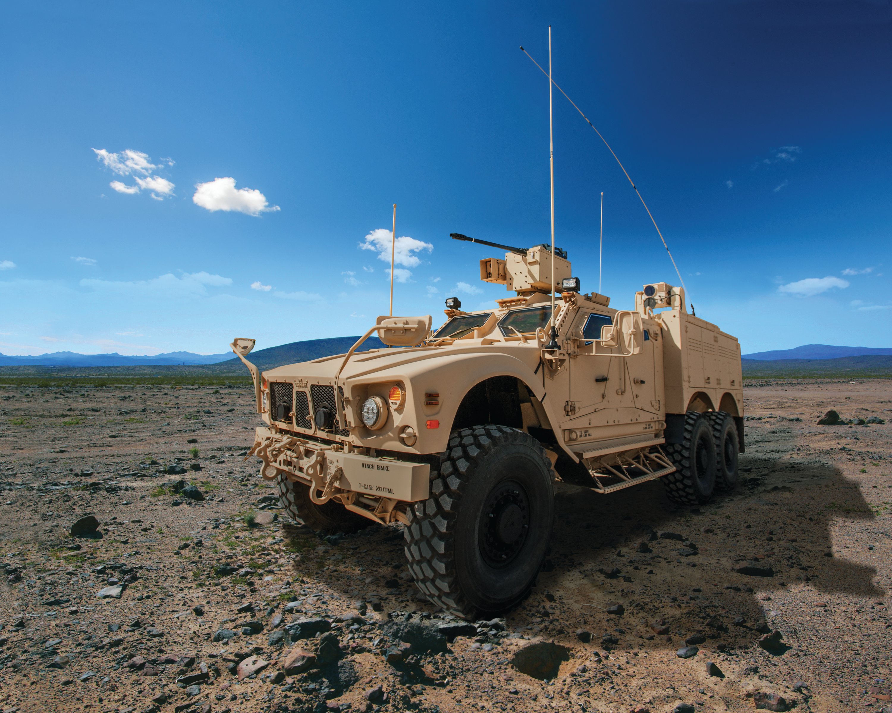 The Oshkosh Corp.'s M-ATV 6x6 on dirt under a blue sky