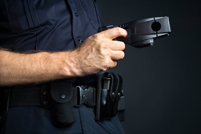 A police officer holding a Taser in his right hand 
