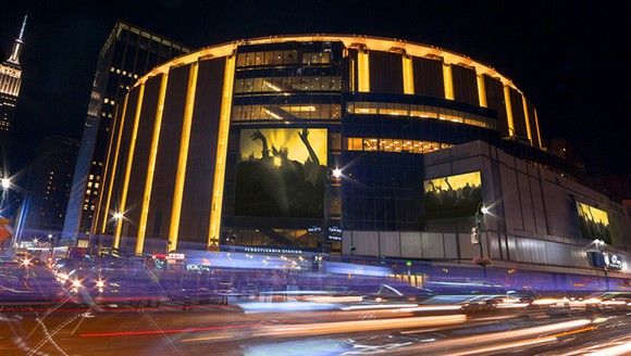 A view of Madison Square Garden at night from the outside