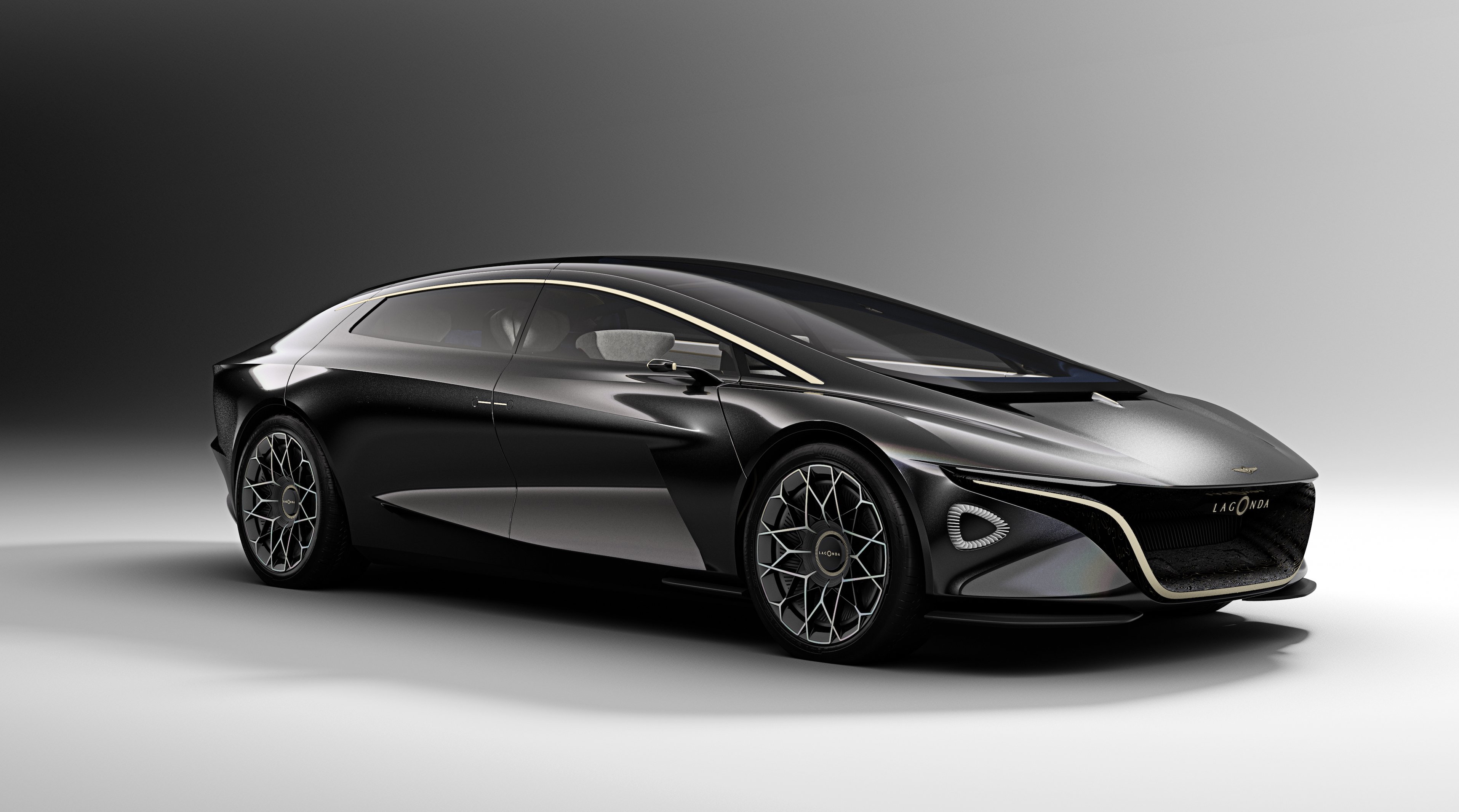 A dark gray Lagonda Vision Concept, a radically styled four-door sedan.